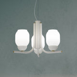 Faronne 3 Light Glass Chandelier in white, three opal glass barrel shades on curved iron arms with brass accents, shown against a muted teal background.