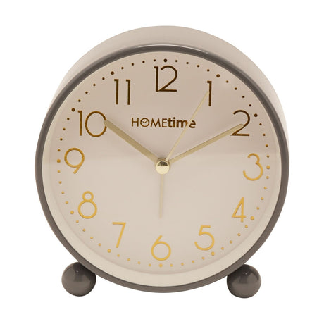 Round metal case alarm clock in glossy grey with a cream dial, gold Arabic numerals and hands, set on two round feet, shown on a plain white background.