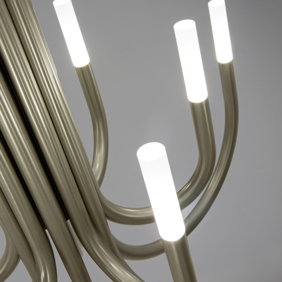 Close-up of ThePalm LED 12 Light Chandelier in satin nickel, showing curved tubular arms with white cylindrical acrylic diffusers against a plain grey background.