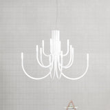 ThePalm LED 18 Light Chandelier in white, with slender arms curving outward from a fluted stem to glowing LED tips, shown against a light grey gridded wall.
