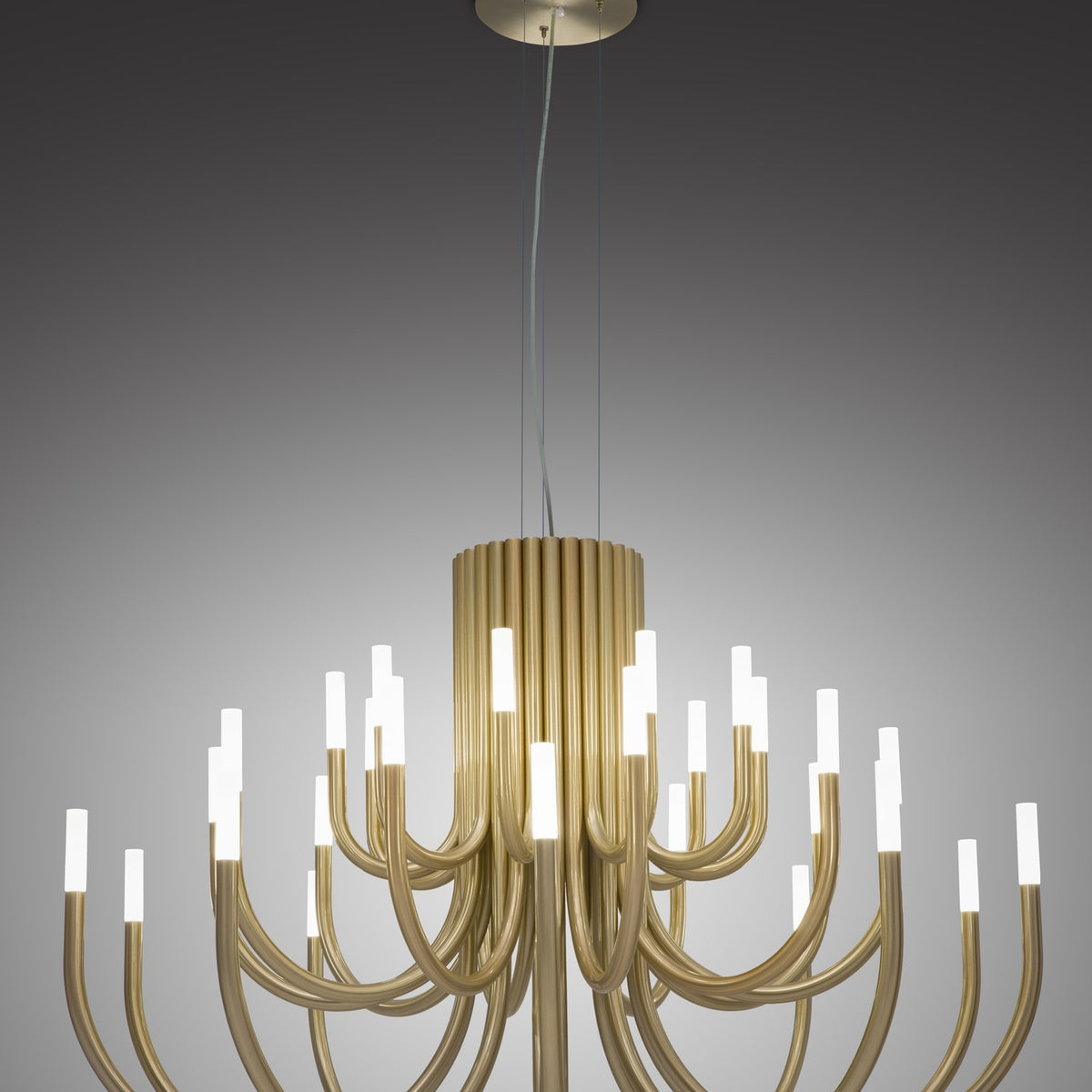 ThePalm LED 30 Light Chandelier in satin gold, with tiered curved tubular arms radiating from a central column, each tipped with glowing acrylic ends, against a grey studio background.