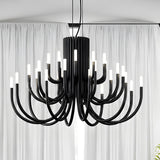 ThePalm LED 30 Light Chandelier in black, with curved iron arms rising in tiers from a fluted column, each tipped with glowing white acrylic, shown against sheer curtains.