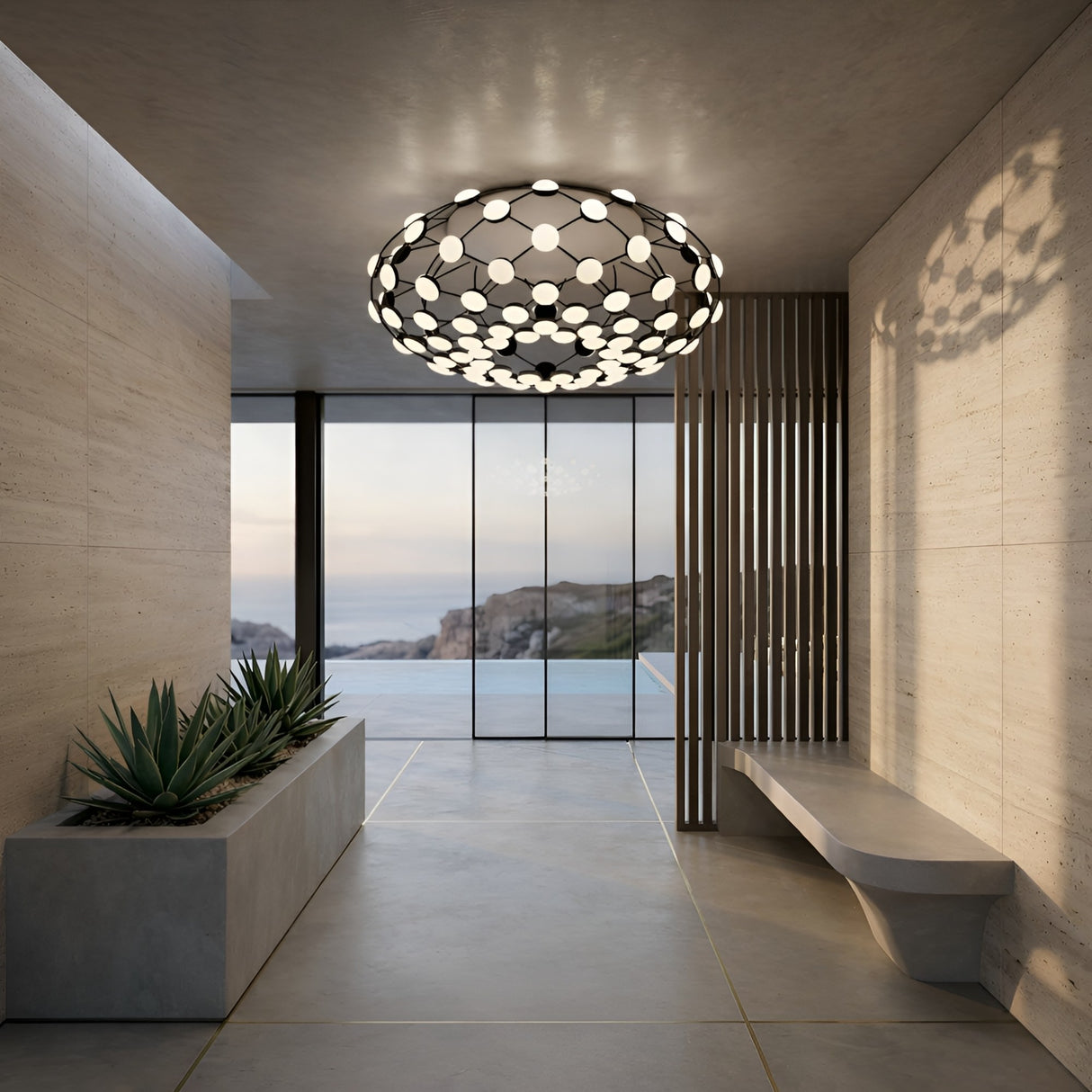 A modern hallway with concrete walls and floors showcases the Mesh LED Flush Ceiling Light in black, a built-in planter with succulents, a minimalist bench, and large glass doors that overlook a pool and rocky landscape.