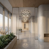 A modern hallway with large windows, marble floors, indoor plants, and the Mesh LED Flush Ceiling Light - Black. Sunlight streams in, creating a bright and elegant ambiance with city views outside.