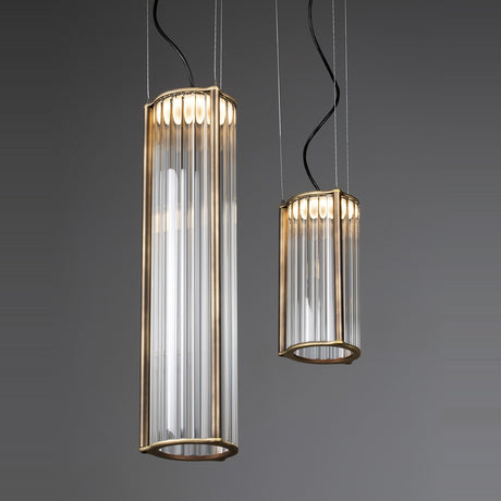 Kalvenne LED glass pendant lights in two sizes, cylindrical ribbed glass columns in satin bronze iron frames, suspended on thin cables against a grey background.