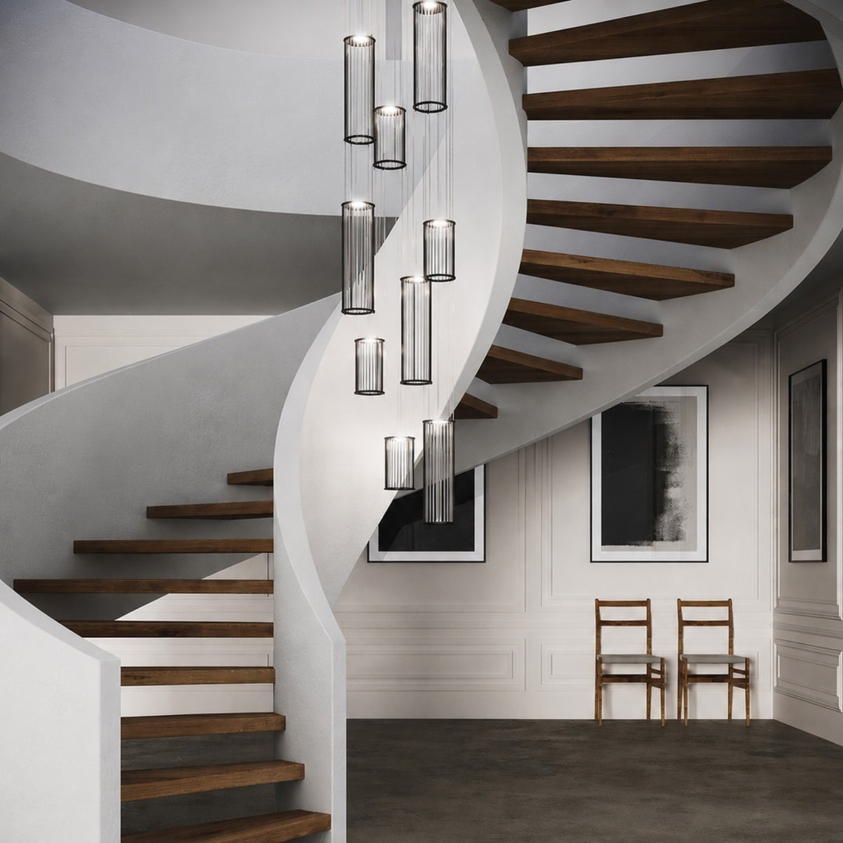 Kalvenne LED glass pendant lights in black, shown as multiple ribbed glass columns in fine black iron frames cascading beside a spiral staircase with wood treads.