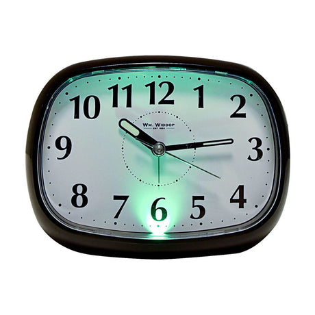 Oval alarm clock in glossy black plastic with white dial, black Arabic numerals, luminous hands and illuminated green backlight, shown on a plain white background.