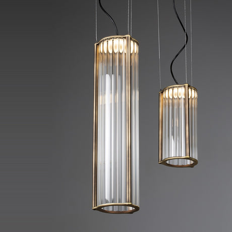 Kalvenne LED glass pendant light in satin bronze, two cylindrical fixtures with ribbed glass columns in iron frames, suspended on thin cables against a grey background.