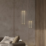Kalvenne LED Glass Pendant Light in black, two slim ribbed-glass cylindrical shades in a black iron frame, hung at different heights above a sofa against a textured wall.