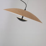 The Ginger LED Small Pendant Light - Black & Brown features a curved light wood shade and a compact black dome, suspended by a black cord for a modern look.