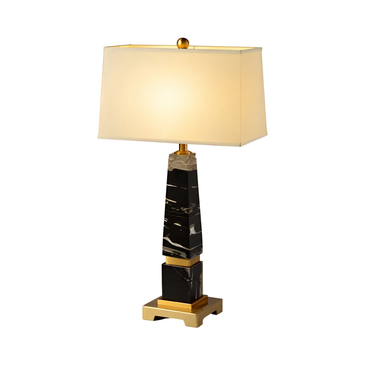 The Aurevon 1 Light Tapered Marble Table Lamp features a rectangular beige shade, brass accents, and a black marble base with white veining, all set against a plain white background.