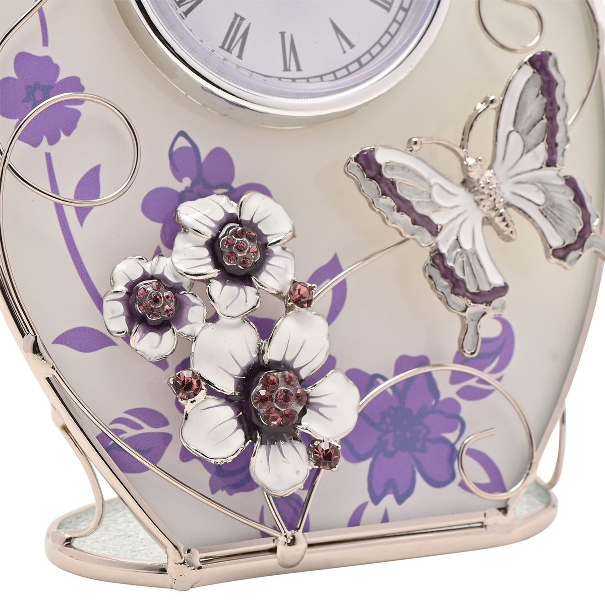 Close-up of a purple oval glass mantel clock featuring frosted floral glass, a raised silver and white butterfly, and crystal-centred white flowers on a silver base.