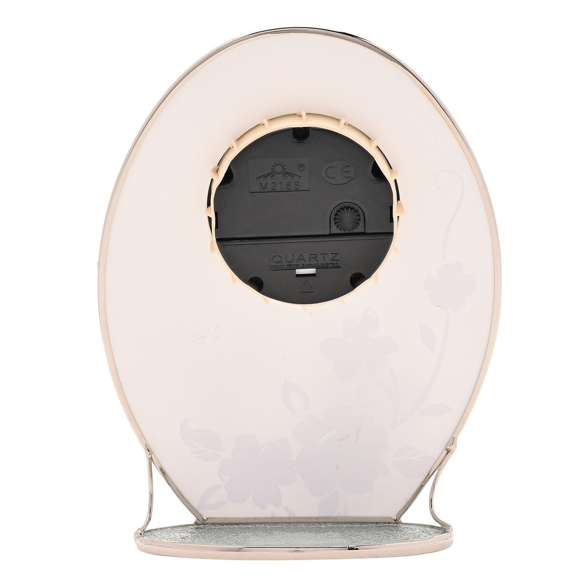 Rear view of the Butterfly & Crystal Flowers Oval Glass Mantel Clock showing the quartz movement, battery compartment, and chrome stand on a white background.