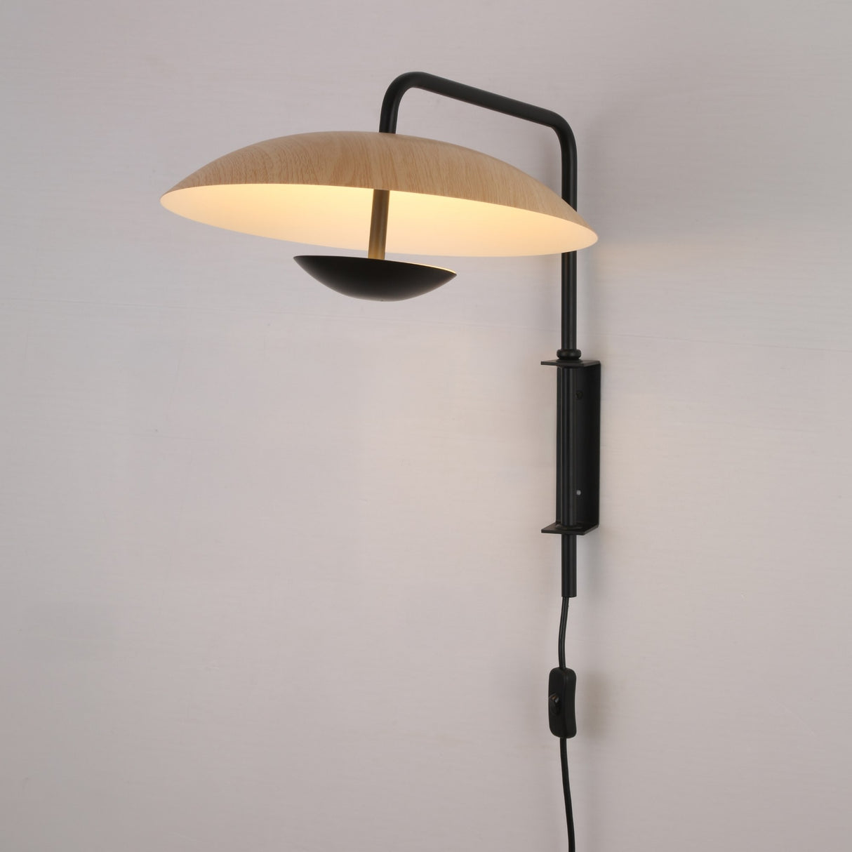 Niori Ginger LED Wall Light in black and brown with illuminated round wood-toned disc shade, slim metal arm, wall mount, and inline switch cord.