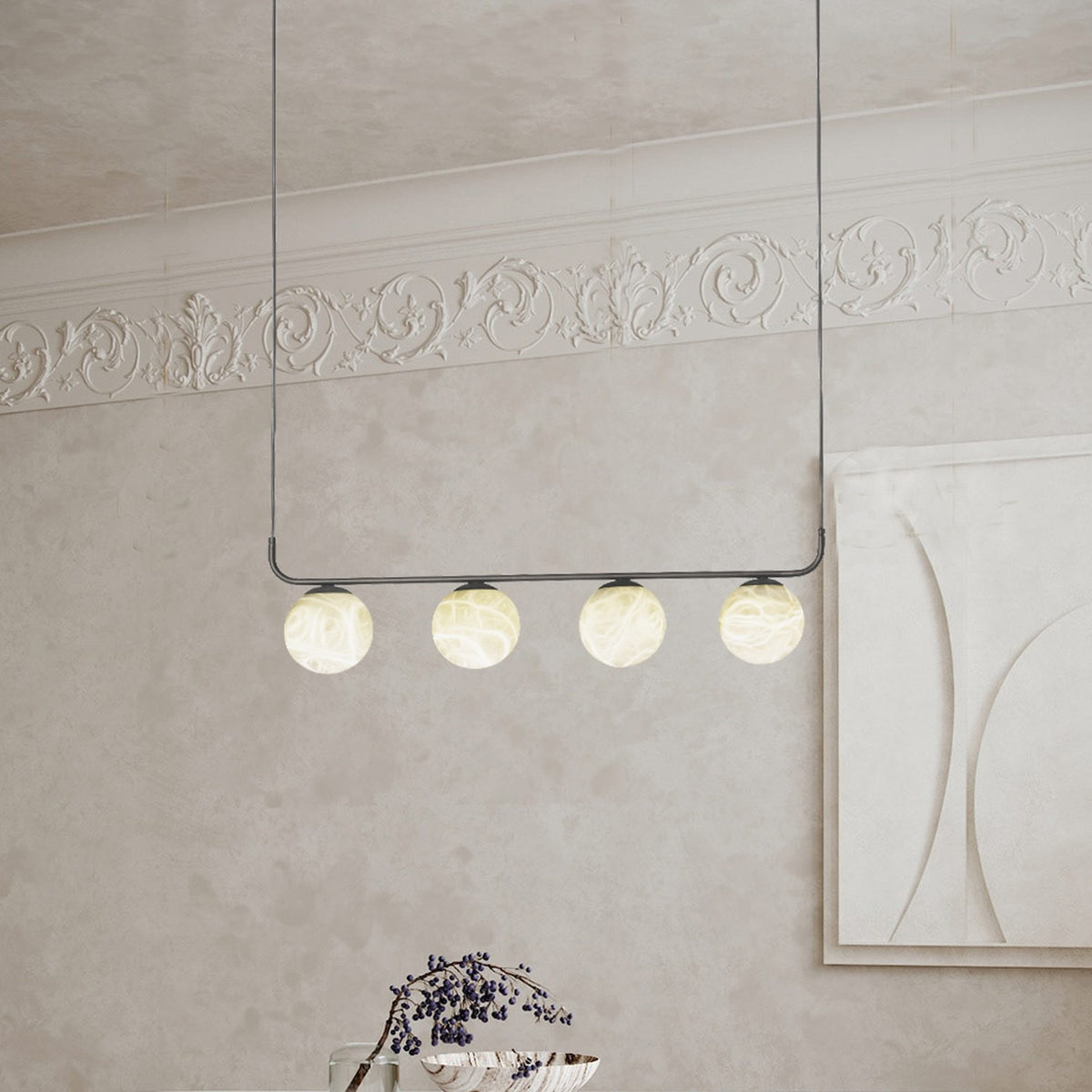 Halvessa LED 4 Light Alabaster Pendant Light in black, four glowing alabaster globes on a slim horizontal bar, shown hanging in a room with ornate cornicing.