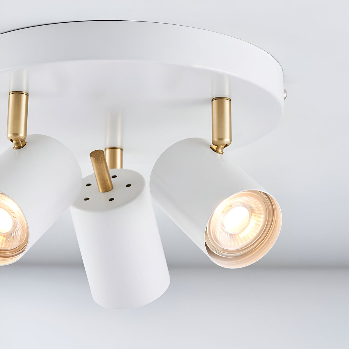 Endon Radnor 3 light round spotlight in matt white with brass fittings and three adjustable GU10 heads on a circular ceiling plate.