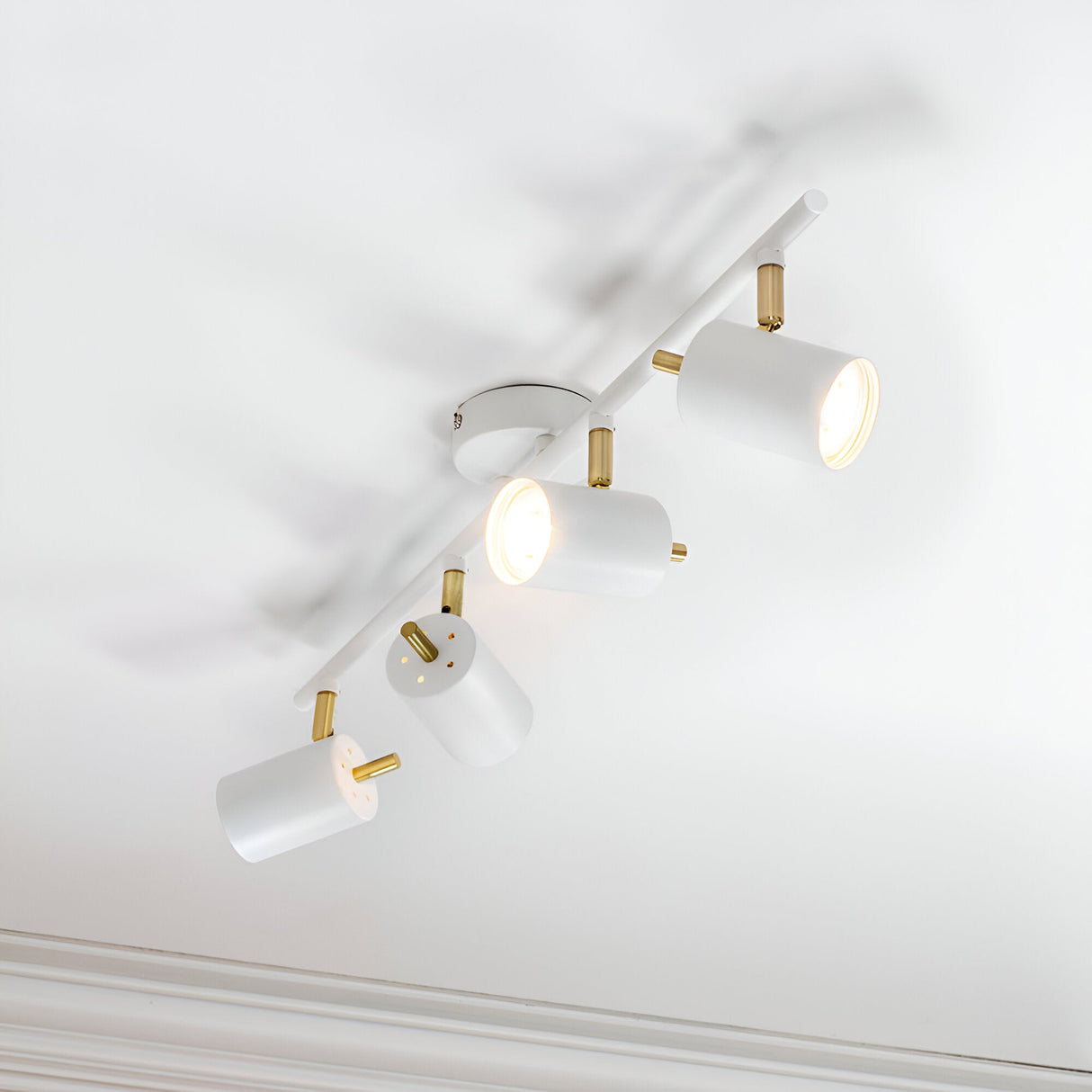 Endon Radnor 4 Light Spotlight Bar in matt white with brass fittings, four adjustable cylindrical heads on a slim ceiling-mounted bar.