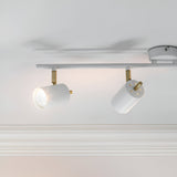 Endon Radnor spotlight bar in matt white with brass detailing, showing two adjustable GU10 heads angled from a slim ceiling-mounted bar.