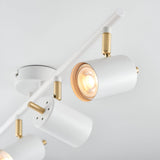 Endon Radnor 4 light spotlight bar in matt white with brass detailing, cylindrical adjustable heads and GU10 lamps, shown close-up against a pale ceiling.
