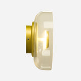 Side view of the Blossom LED Glass Wall & Ceiling Light in Gold, featuring a gold-colored base and a clear glass shade. The partially visible light bulb emits a warm glow against a neutral background.