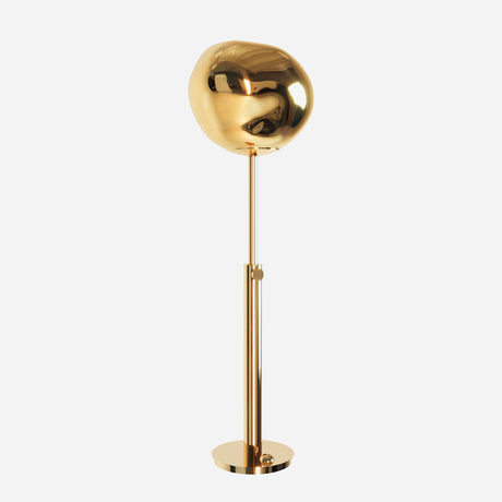 The Lava Floor Lamp - Gold showcases a modern, gold metallic finish with lava-like effects. It features a spherical shade on a tall, sleek stand. With its circular base and polished surface, the lamp beautifully reflects light, embodying a minimalist and contemporary design with organic elements.