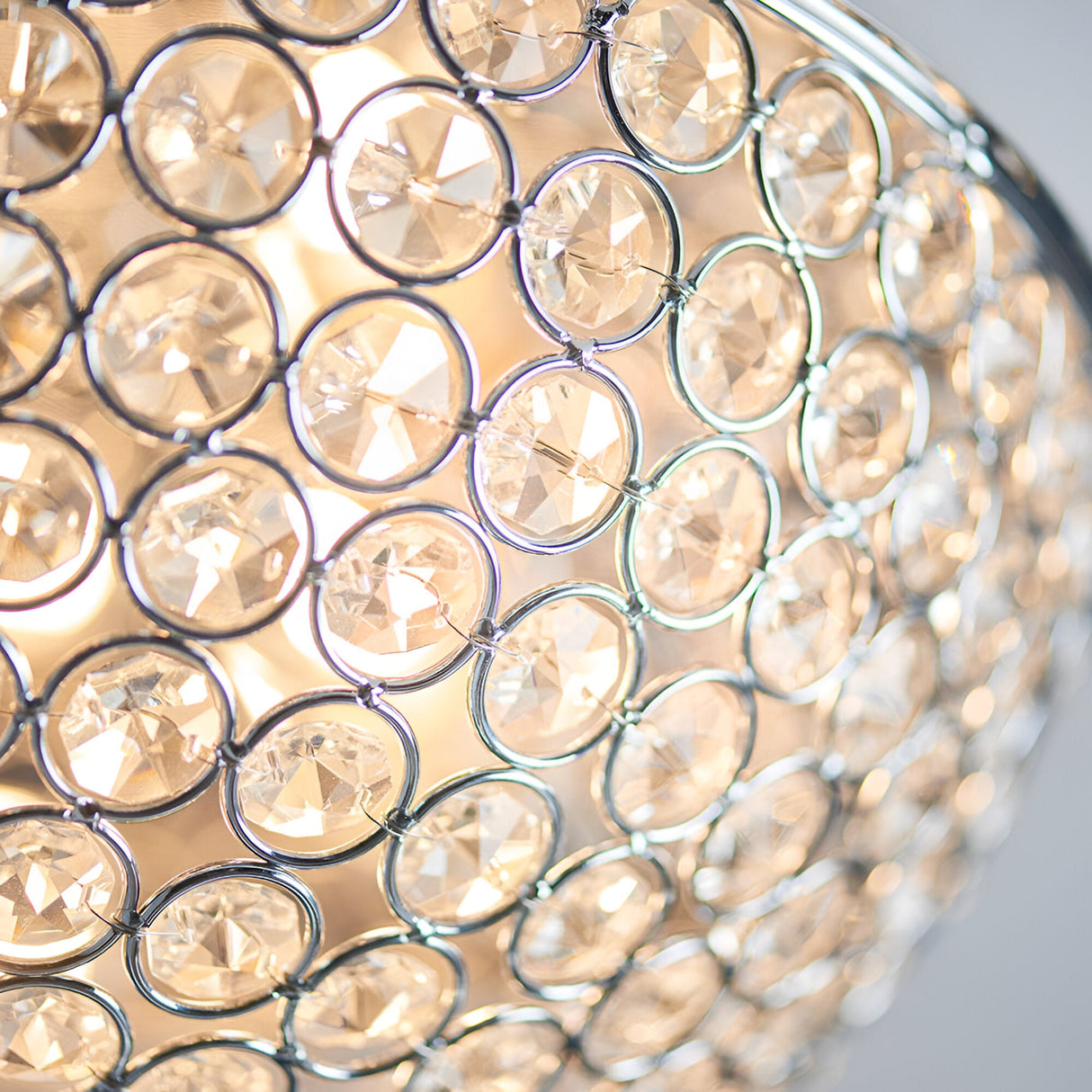 Close-up of the Endon Cordelia flush bathroom ceiling light showing faceted crystal beads set in a chrome frame with warm illumination behind.