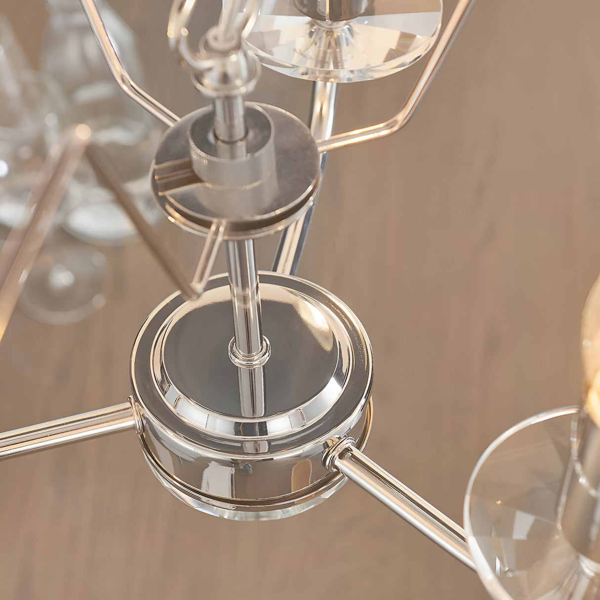 Close-up of the Endon Castdon 3 Light Pendant showing the polished nickel central hub, arms, and K9 crystal bobeches beneath faux silk shades.