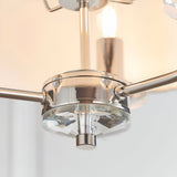 Close-up of the Endon Castdon 3 light pendant showing the polished nickel central hub, K9 crystal bobeche detail, and vintage white faux silk shade.