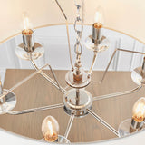 Castdon 6-light pendant close-up showing nickel arms, crystal bobeches, exposed E14 bulbs and central chain, with white shade visible above.
