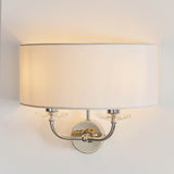 Castdon 2 Light Wall Light in nickel with white semi-circular fabric shade, twin arms and crystal accents, shown on a plain wall background.