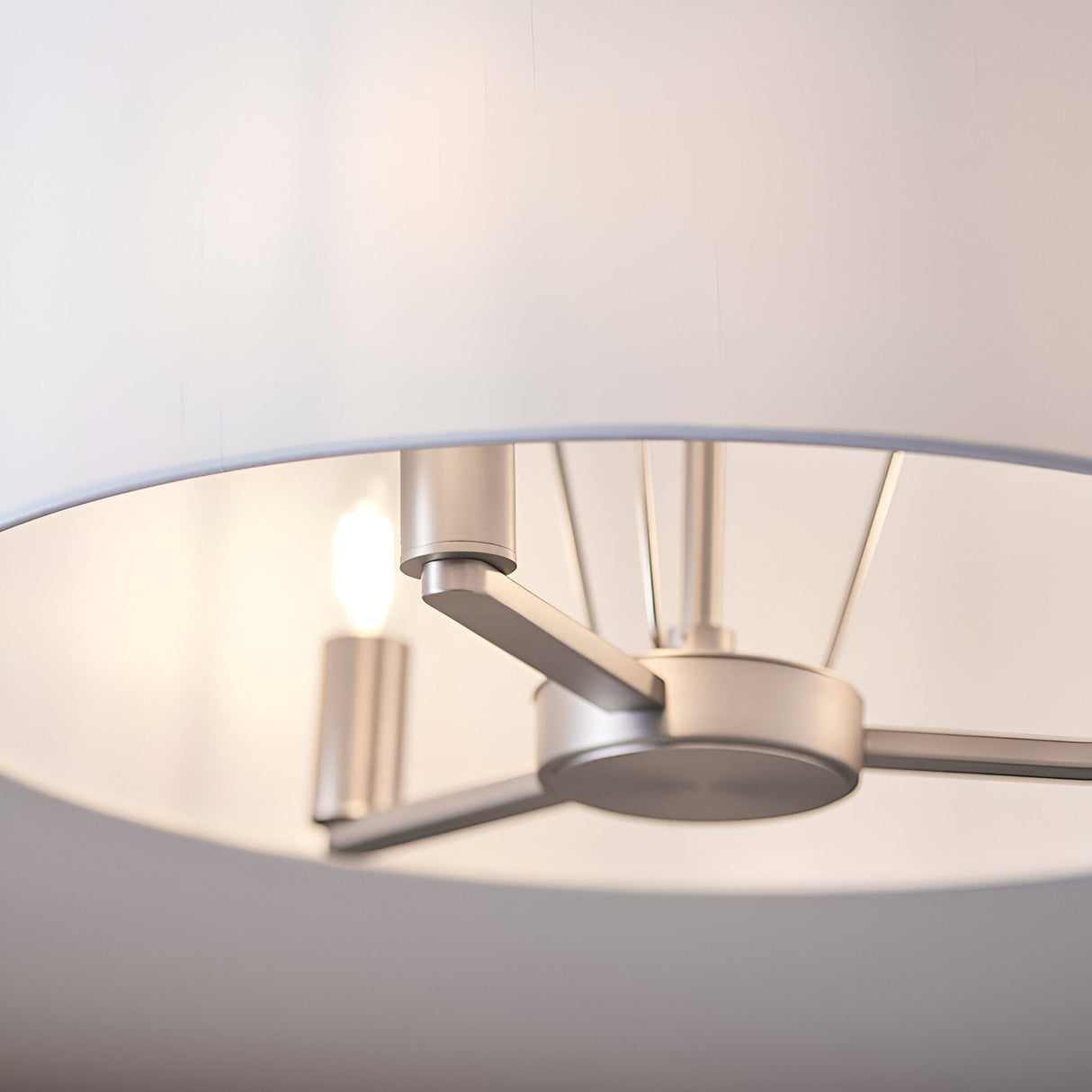 Close-up of Endon Bexley Large 3 Light Pendant interior showing brushed nickel three-arm frame with E14 lamps beneath a white faux silk shade.