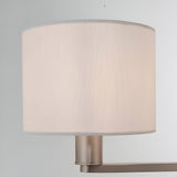 Close-up of the Bexley 3 Light Pendant in nickel, showing one white faux silk drum shade on a brushed metal arm against a plain light background.