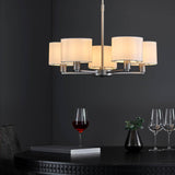 Bexley 5 Light Pendant in matt nickel with white faux silk drum shades, shown above a dark dining table in a moody dining room setting.
