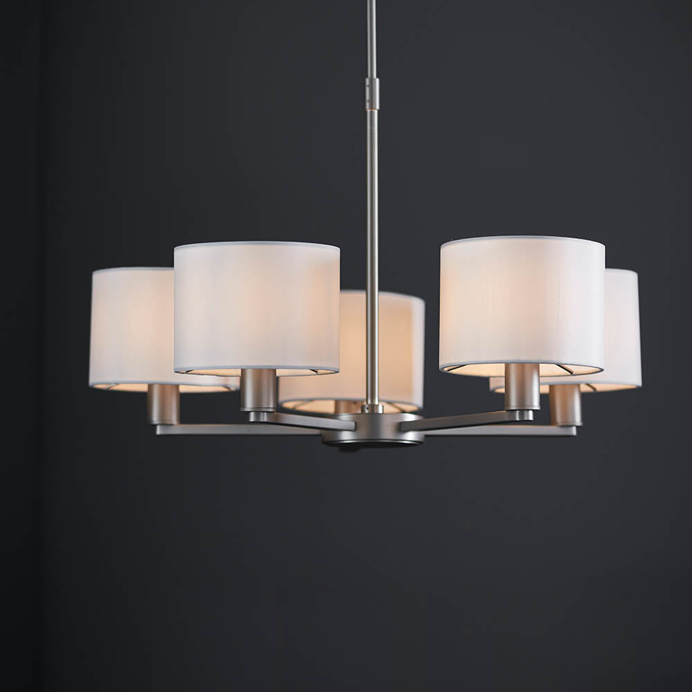 Bexley 5 Light Pendant in matt nickel with five curved arms and white faux silk drum shades, shown against a dark background.