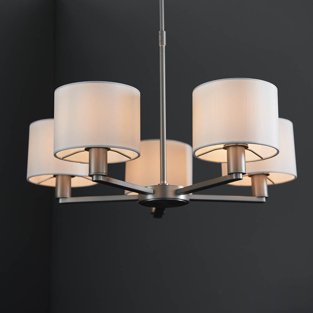Bexley 5 Light Pendant in matt nickel, five curved arms with white faux silk drum shades, shown against a dark background.