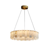 The Valeris 12 Light Layard Panel Alabaster Chandelier in Soft White & Brass features a modern circular design with a brushed brass mount, black suspension cables, and vertical alabaster glass panels that gently diffuse warm light.