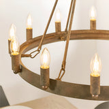 Bevgrove 12-light pendant close-up showing an aged metal ring frame with candle-style E14 fittings and rustic support chains against a plain background.
