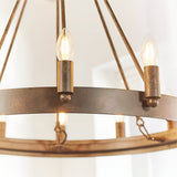 Close-up of the Bevgrove 12 Light Pendant's aged metal ring frame with candle-style E14 fittings and exposed filament bulbs, set against a white interior.