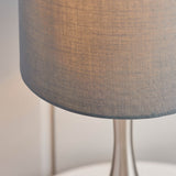 Close-up of the Endon Chartbury LED table lamp showing its grey fabric drum shade and slender satin nickel base against a pale background.