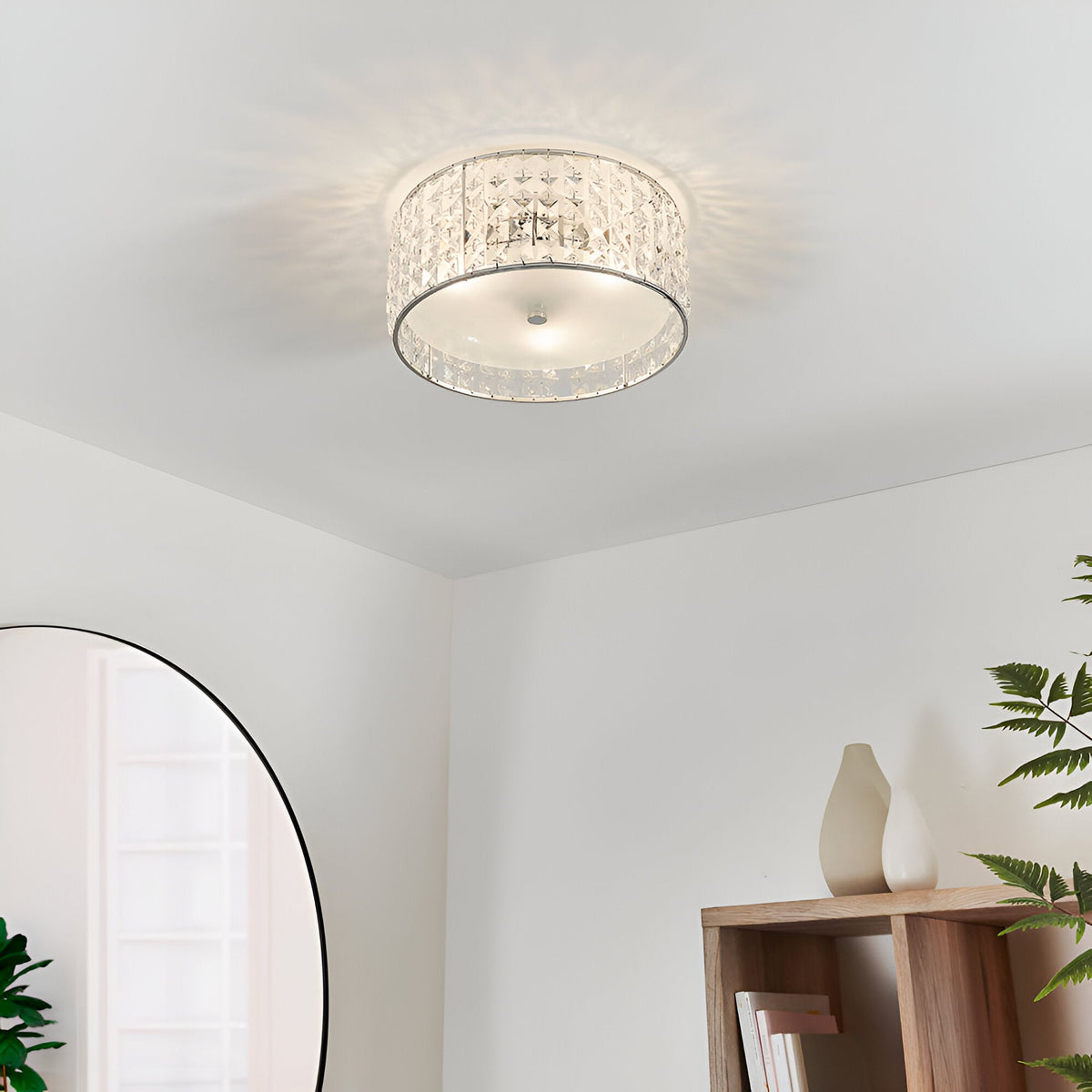 Endon Ophelia 3 light crystal flush ceiling light in chrome, illuminated on a white ceiling above a bedroom corner with an arched mirror and wooden shelf.