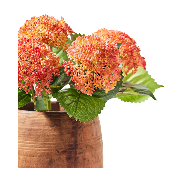 Libra Interiors Textured Coral Hydrangea artificial flower stems with clustered coral and amber blooms and green leaves in a rustic terracotta pot.
