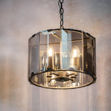 Bevshaw 4-light pendant in slate grey with a drum frame, bevelled smoke glass panels, exposed candle bulbs, and a chain hang.