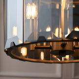 Bevshaw 4 Light Pendant close-up showing bevelled smoke glass panels, slate grey frame, and exposed filament bulbs with brass-toned fittings.