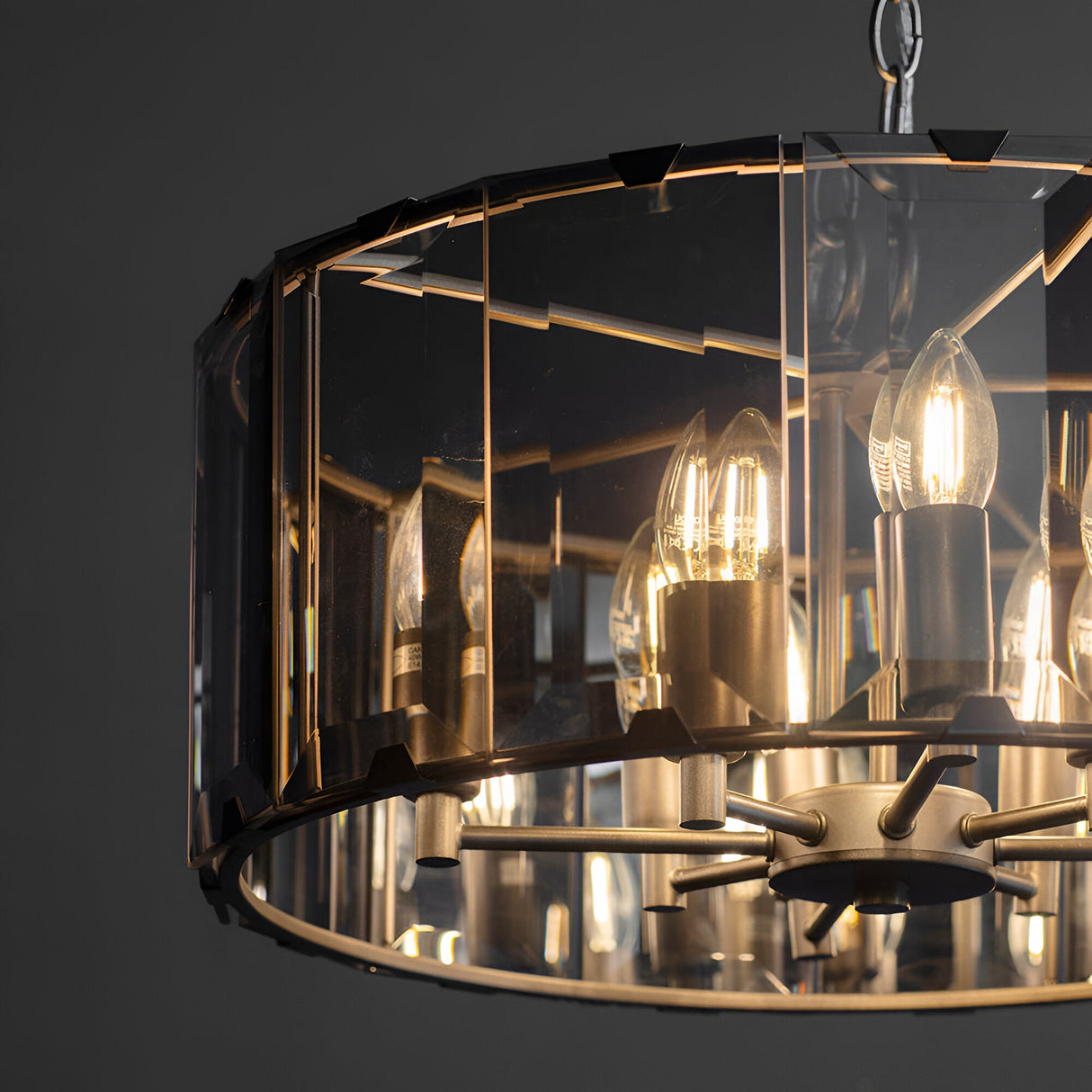 Close-up of Endon Bevshaw 8 light pendant showing bevelled smoke glass panels, slate grey frame, and lit E14 candle bulbs on a dark background.