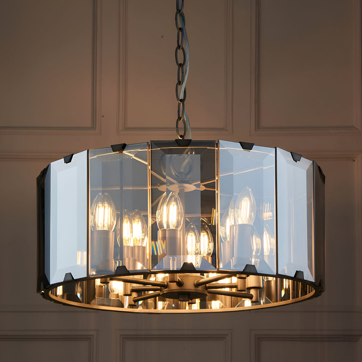 Endon Bevshaw 8 light pendant with bevelled smoke glass panels and slate grey frame, suspended from a chain against a panelled wall.