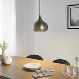 Ashleigh Pendant in matt nickel with a rounded teardrop shade, hung above a wooden dining table set with plates, cutlery and glassware.