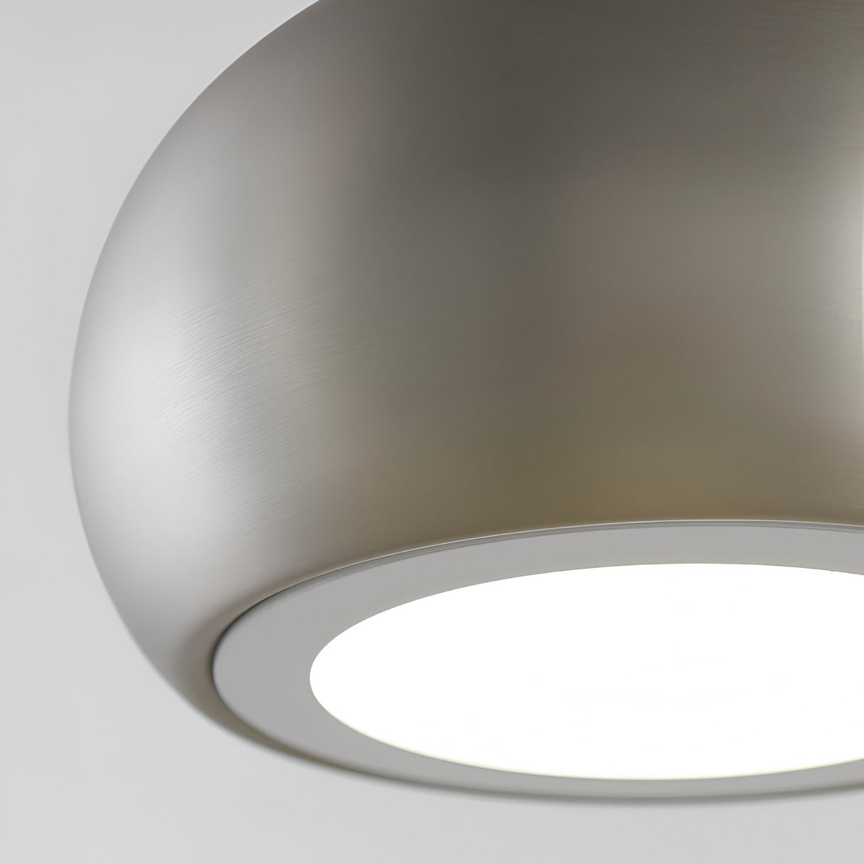 Close-up of the Ashleigh Pendant in matt nickel, showing its rounded metal dome and white diffuser lit against a plain light background.