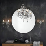 Endon Crandon 5 light bathroom chandelier in polished chrome with crystal droplets, reflected in a round mirror above a dark tiled vanity.