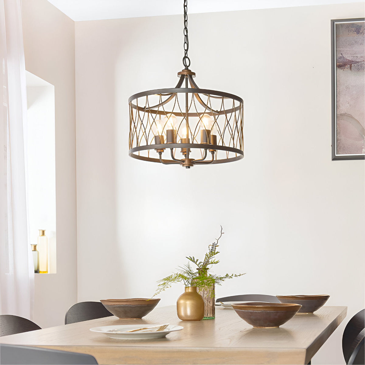 Hulton 5 Light Pendant in bronze and black open lattice metalwork with five exposed bulbs, hung above a dining table on a black chain.