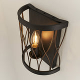 Endon Hulton wall light with a curved steel cage in matt black and rustic bronze, single lit E14 candle bulb, mounted on a white wall.